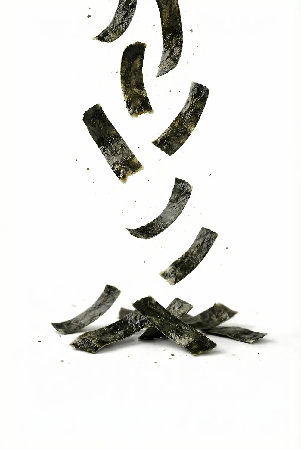 Close up of crispy roasted seaweed snack strips falling showing premium texture